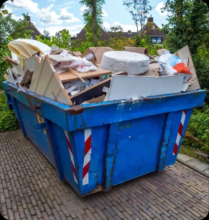 Builders skip full of construction debris on a brick path